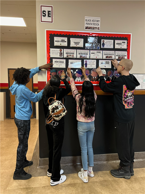 Strong Vincent students put the finishing touches on a Black History month trivia bulletin board.