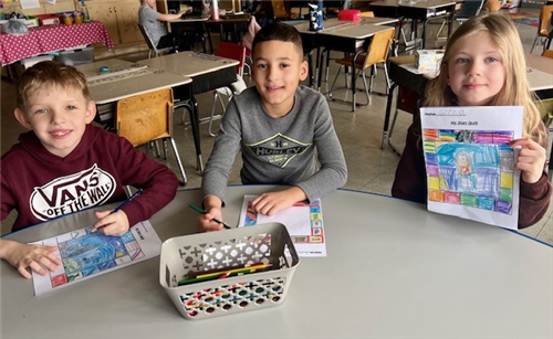 The second grade students learned facts about contemporary artist and writer Faith Ringgold. Three students show off works. 