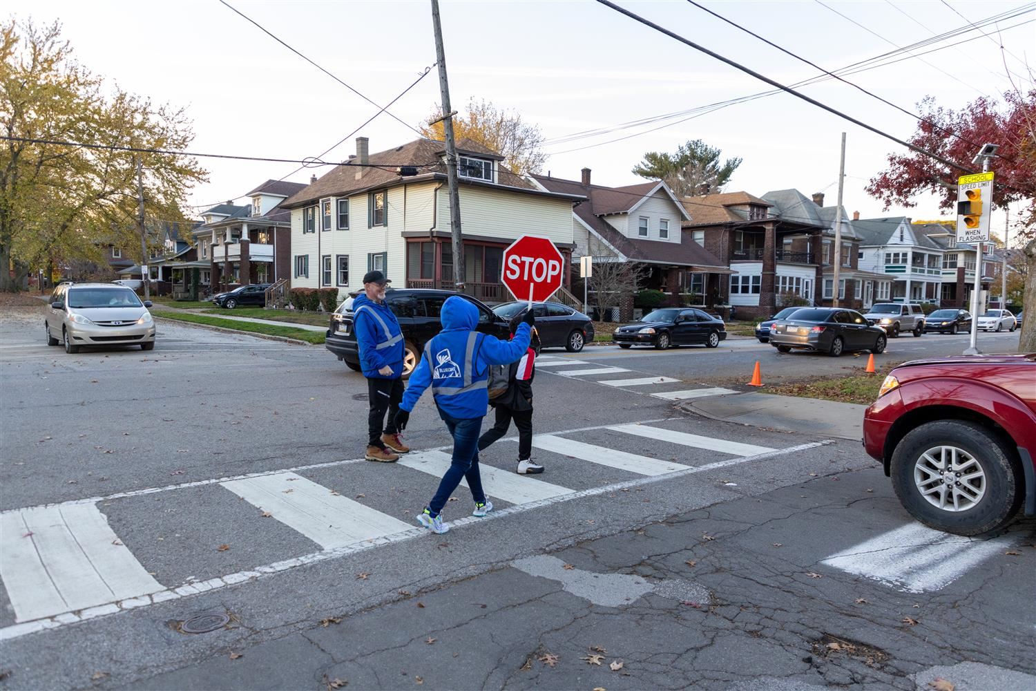 A member of the Blue Coats peacekeeping initiative helps students cross the road safely.