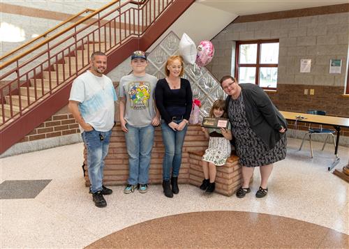 Carmyn Randazzo, Lincoln Elementary's May 2023 Stairclimber, poses with her plaque, family members and Principal Huffman.