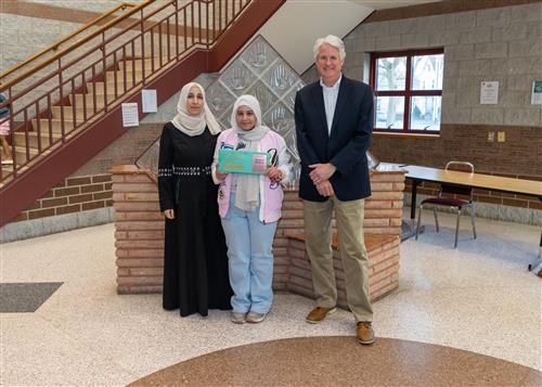 Yasmeen Basbous, Diehl's March Stairclimber, poses with her plaque, a family member, and Principal Tim Sabol.