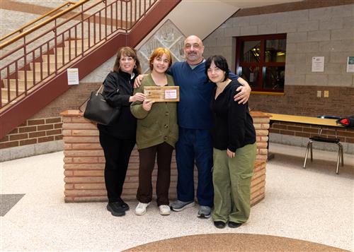 Ziva Kerchansky, Strong Vincent's January 2023 Stairclimber, poses with her plaque, family members and Principal Gloystein.
