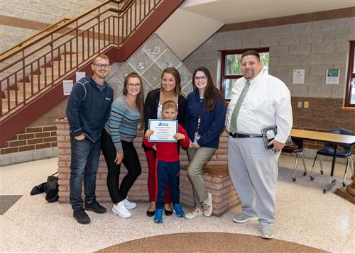 Jaxon Gallentine, Connell's October Stairclimber, poses with his certificate, family members, and school staff.
