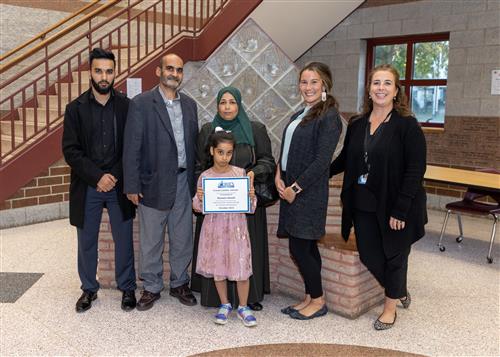 Raneem Aloush, Edison's October Stairclimber, poses with her certificate, school administrators, and family members.