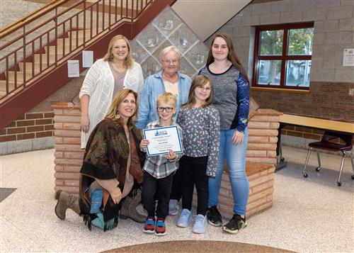 Jace Mead, Pfeiffer-Burleigh's October Stairclimber, poses with his certificate, family members, and school staff.